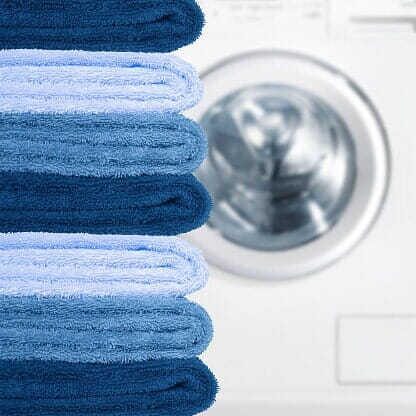 Pila de toallas al lado de lavadora.